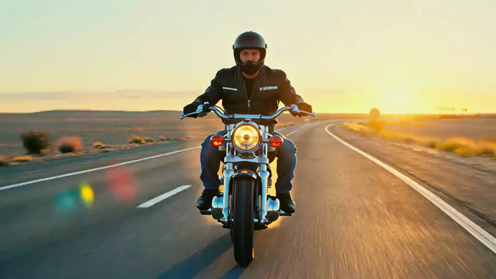 Rider accelerating through a bend on an open highway at golden hour